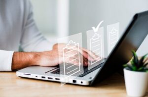 Professionista che utilizza un computer portatile con icone digitali, simbolo di investimenti tecnologici e iperammortamento 2026 per le PMI.